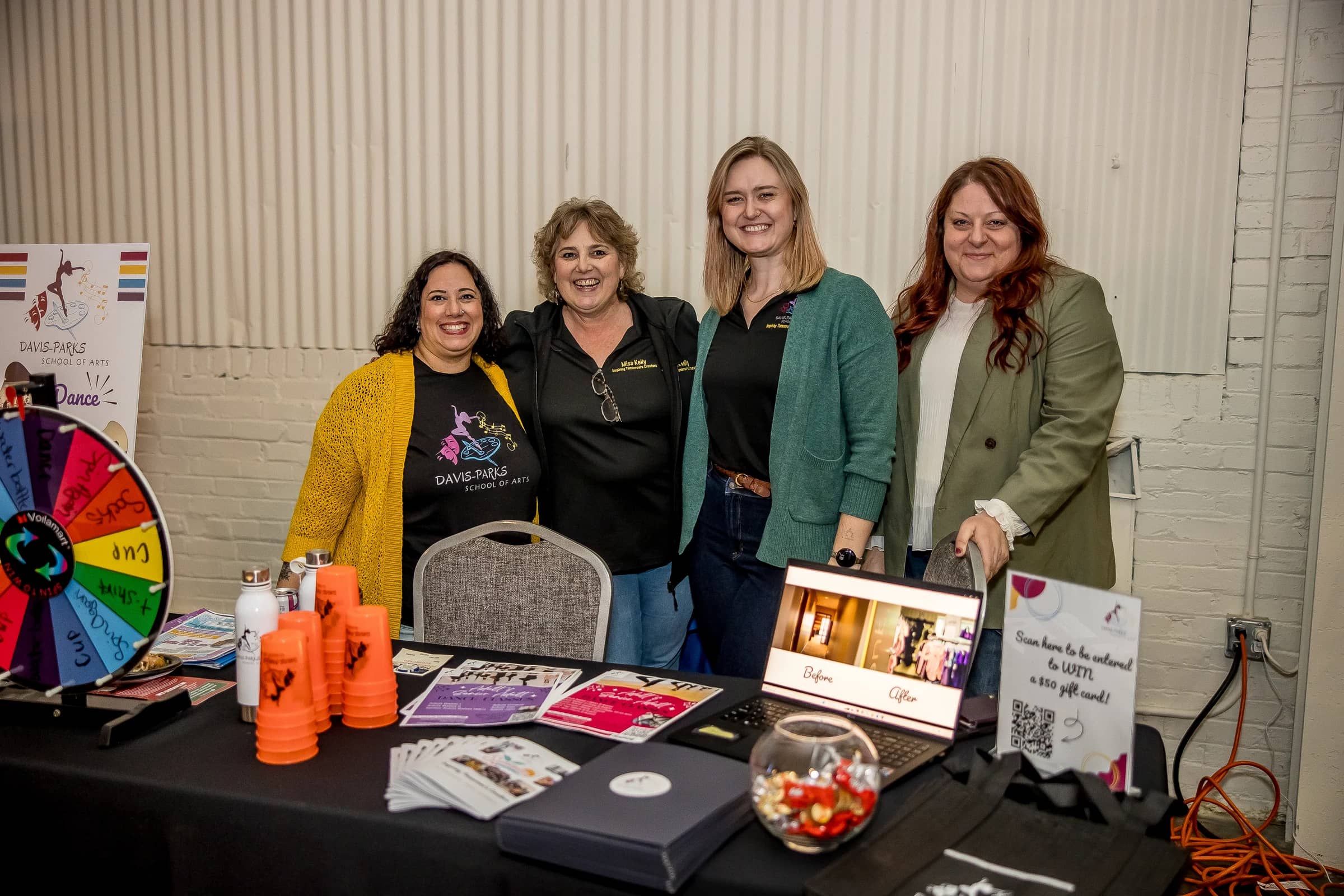 Four exhibitors smiling behind their table at the Business Circuit Expo